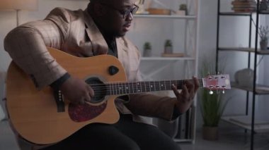 Gitar sanatçısı evde şarkı söylüyor.