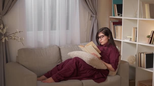 Książka wypoczynek czytanie kobieta strona główna historia kanapa — Wideo stockowe