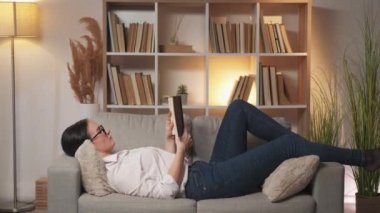 Evde okuma hobisi. Kanepede akıllı kadın kitabı.