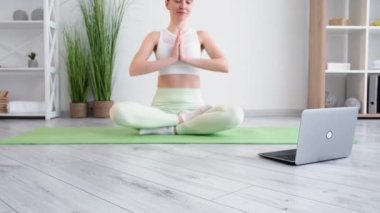 Meditasyon yapan kadın yogası çevrimiçi ev bilgisayarı dinlendiriyor.