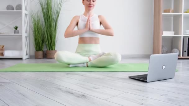 Meditating woman yoga online home relaxing laptop — стоковое видео