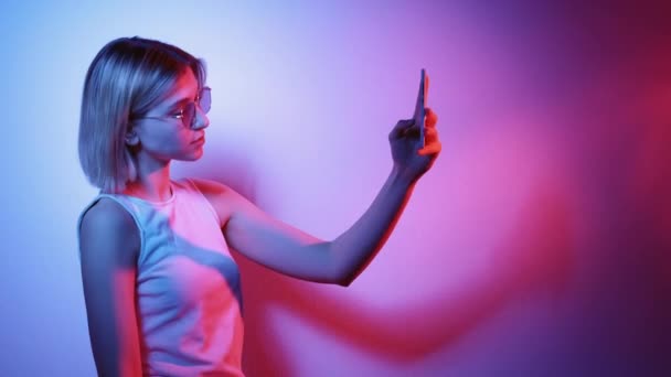 Gadżet ludzie social media neon dziewczyna biorąc selfie — Wideo stockowe