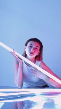 Işık terapisi yüzü beyaz lamba pozu veren kadın.