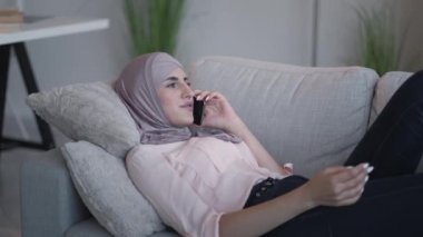 Ev telefonuyla konuşan kadın rahat koltuğu arıyor.