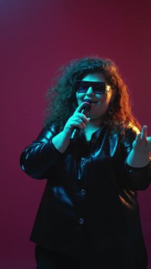Sunucu kendine güvenen kıvrımlı kadın mikrofonunu göster