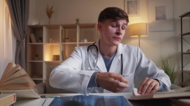 Junior doctor positive man online consultation — стоковое видео