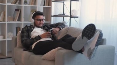 Müzik dinlendirici şarkı, kulaklık, kanepe.