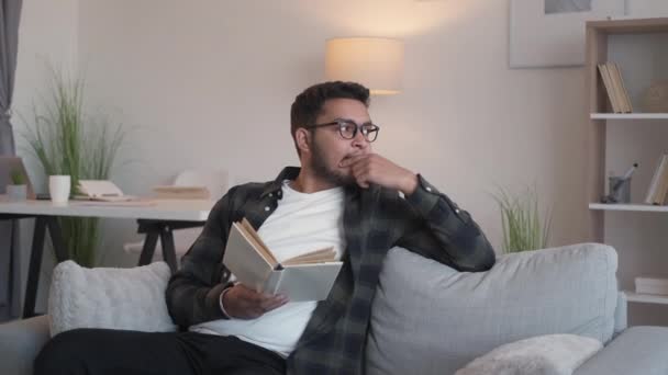 อ่านหนังสือผู้ชายบ้านพักผ่อนเรื่องราวที่ผ่อนคลายโซฟา — วีดีโอสต็อก
