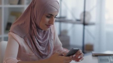 Mobil internet mesajlaşması. Telefoncu kadın ev masası.