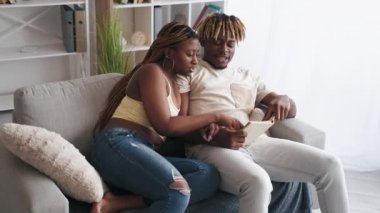 Çift evde çalışıyor, birlikte kitap okuyor.