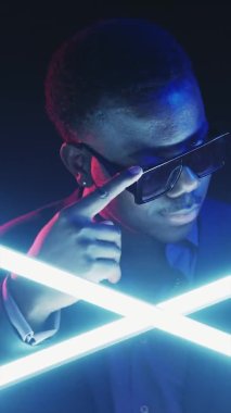 Göz kırpan adam. Flört havasında. Gece kulübü döngüsü. Bumerang hareketi. Sevecen yakışıklı adamın şık güneş gözlüklü parlak ışıkla göz kırpan yüzü..