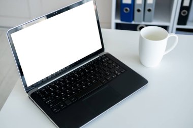 Bilgisayar modellemesi. Çevrimiçi teknoloji. İş yeri. Açık dizüstü bilgisayar ve boş ekran açık ofis odasının iç tarafında duruyor..