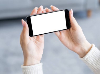 Mobil video. Çevrimiçi teknoloji. Dijital bir model. Elinde boş ekranla akıllı telefonu tutan tanınmayan bir kadın..