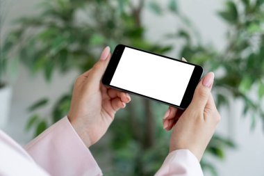 Sanal yaşam. Dijital bir model. Mobil bağlantı. Aydınlık odanın içinde elinde boş ekranlı akıllı telefon tutan tanınmayan bir kadın..