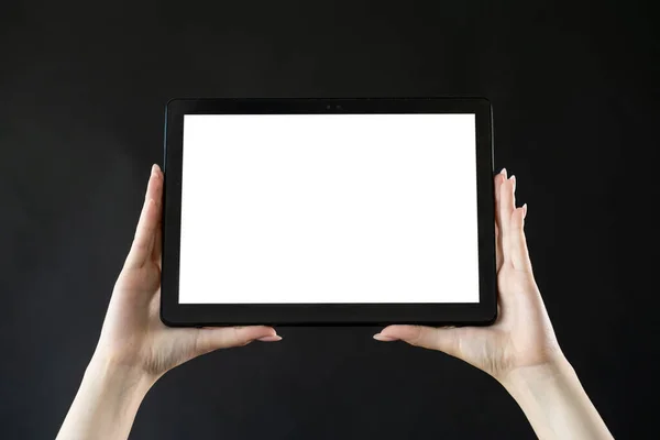 Mobile technology. Digital information. Advertising background. Female hands holding tablet computer with blank white screen isolated black.