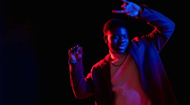 Siber punk partisi. Neon dansı. Gece kulübü afişi. Keyifli, kaygısız bir adam gece hayatının tadını çıkartıyor. Canlı kırmızı mavi bir ışık. Karanlık, boş bir arka planda izole edilmiş..