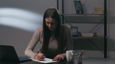 İş sıkıntısı. Aşırı çalışma var. Aşırı çalışma bunalımı. Stresli kadın yazar geceleri evde dizüstü bilgisayar masasında kağıt yırtıyor..