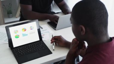 Veri analizi. Hesap yöneticisi. İlerleme değerlendirmesi. Afrikalı profesyonel muhasebeci dizüstü bilgisayarın ofis içi iş yerindeki pazar grafiklerini analiz ediyor..