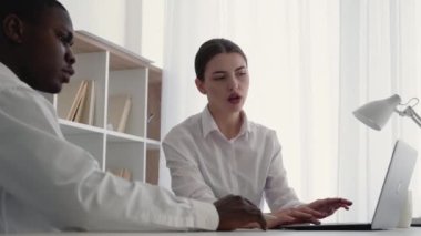 Üretken takım çalışması. İş koçluğu. Uluslararası ortaklık. Tatmin olmuş karışık ırk ortakları laptopta Afro erkek beyaz kadın başarıyı ofiste beşlikle kutluyor..