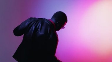 Komik dans. Tuhaf bir ruh hali. İyimser bir hayat. Gece kulübü eğlencesi. Bumerang hareketi. Heyecanlı, kaygısız, mutlu adam. Parlak neon ışıklı GIF döngüsünde müzik ritminin tadını çıkarıyor..
