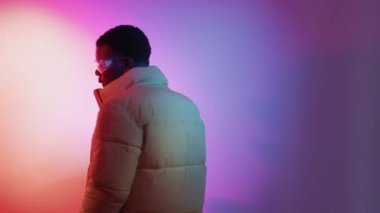 Modern moda. Şehir tarzı. Neon ışığı insanları. Bumerang hareketi. GIF döngüsü, sokak kıyafetleri içinde dönen şık bir adam canlı gradyan boş uzay.