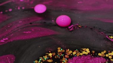 Parlak boya dalgası. Yağlı su kabarcıkları. Çemberler akar. Pigment damlası. Parlak soyut arka planda yüzen neon pembe mürekkep altın pulları.