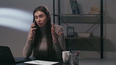 Telefon şikayeti. İşle ilgili. Şirket çatışması. Sinirli, sinirli bir girişimci ev işyerinde akıllı telefondan konuşuyor..