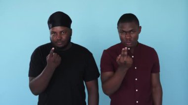 Davetkar bir jest. - Gel buraya. Savaş tehdidi. Bumerang hareketi. Mavi arka plan GIF animasyonunda izole edilmiş kızgın ifadeli ciddi, dost canlısı olmayan Afrikalı erkek çetesi..