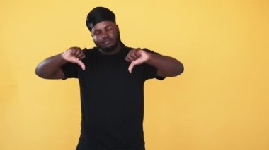 Küçük bir jest. Reddet işareti. Irkçılığı bırak. Huysuz, portakalsız arka planda izole edilmiş el işareti olan Afrikalı bir adamı reddediyor..
