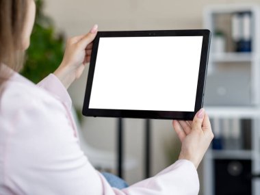 Dijital bir model. Ofis kadını. Mobil bağlantı. Aydınlık odada içi boş ekranlı tablet bilgisayar tutan tanınmayan kadın..