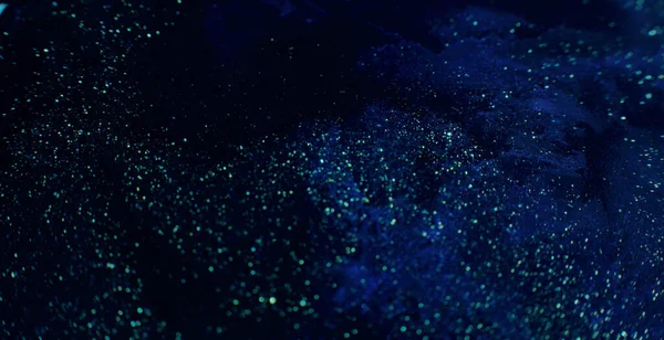 Parlak boya sıvısı. Volkan tozu. Koyu mavi sıvı akış arkaplan görüntüsünde odaksız altın pullu parıltı RED Sinema Kamerasında.