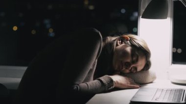 İş yorgunluğu. Yorgun bir öğrenci. İş yorgunluğu. Yorgun, uykulu, aşırı çalışan, işkolik bir kadın gece geç saatlerde laptopçu masasında uyuyor..