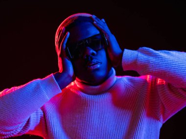 Baş ağrısı. Stres sorunu. Gece hayatı. Acı çeken üzgün bir adam migren ağrısı çekiyor. Kırmızı neon ışıkta. Karanlık arka planda izole edilmiş..