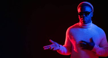 İşaret eden adam. Neon ışıklı pankart. Reklam teklif et. Gerçekten kendine güvenen, kırmızı mavi parıltılı yakışıklı adam koyu renk fotokopi arkaplanında içerik sunuyor..