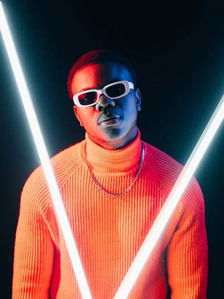 Futuristic man. Cyberpunk fashion. Retro wave style. Confident stylish dude in bright colorful neon light LED lamps on dark background.