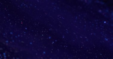 Parlak boya sıvısı. Volkan tozu. Koyu mavi sıvı akış arkaplan görüntüsünde odaksız altın pullu parıltı RED Sinema Kamerasında.