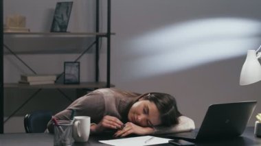 Yorgun iş kadını. Tembel işçi. Gece işi. Yorgun, sorumsuz bir kadın çalışan geç saatlere kadar ofis masasında çalışıyor..
