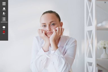 Sanal konferans. Sıkıcı kadın. Ekran modeli. Dikkatsiz bir bayan, masa başında oturmuş, kafasını büyütüyor. Işıklandırma odasının içinde internetten giysi giyiyor..