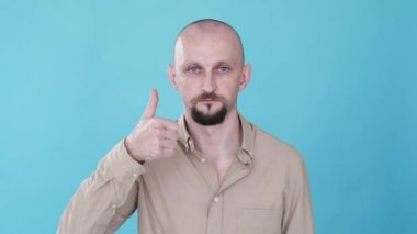 İyi iş çıkardın. İşaret gibi. Bumerang hareketi. Onay teklif et. Kendine güveni tam alaycı bir adam. Mavi boş alan arka planında izole edilmiş el hareketi jesti döngüsüyle destekliyor..