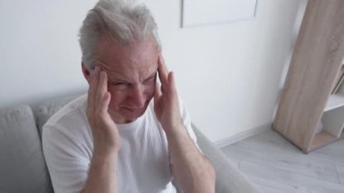 Hap yok. Alternatif terapi. İlaç karşıtı. Ağrı tedavisi. Baş ağrısı çeken orta yaşlı hasta bir adam bakıcıdan reçeteli ağrı kesici almayı reddediyor..