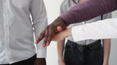 Takım çalışması işi. Çeşitli ortaklıklar. Çok ırklı işbirliği. Karışık ırk ortaklarının yakın çekimi. Takım elleri bir araya gelerek birlik sembolü oluşturuyor..