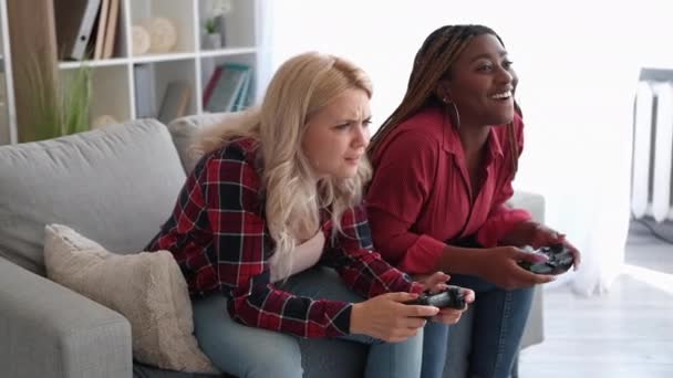 家庭电子游戏 虚拟挑战 周末娱乐 在现代客厅的室内用操纵杆在沙发上玩 惹恼了女性朋友 让她很高兴 — 图库视频影像