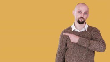 İnsanların reklamını yapmak. Tavsiye edilen adam. Bumerang hareketi. Kendine güvenen adam turuncu boş alanda izole edilmiş görünmez bir gif döngüsüne bakıyor..