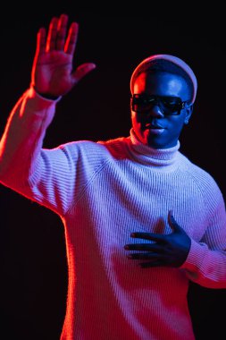 El sallayan adam. Selamlama jesti. Çak bakalım. Neon ışığı insanları. Dost canlısı, modaya uygun, koyu arkaplanda parlak kırmızı bir parıltıyla merhaba diyen adam..