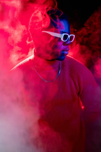 ネオンのヒップスター モダンなファッション ナイトクラブパーティーだ 自信魅力的な男肖像画で煙の流れ鮮やかな赤光でダークスタジオの背景 — ストック写真