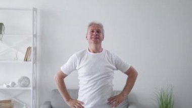Fitness sakatlığı. Kas zorlaması. Ev ödevi kazası. Orta yaşlı bir adam sırt üstü yatarken yaralanmış hafif iç mekanda esneme egzersizi yanlış..