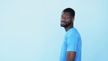 Şaşırmış Afrikalı adam. Onaylama işareti. Harika bir fikir. Etkilenmiş, koyu tenli, neşeli adam. Mavi, boş uzay reklam geçmişine izole edilmiş bir jest gibi kabul ediyor..