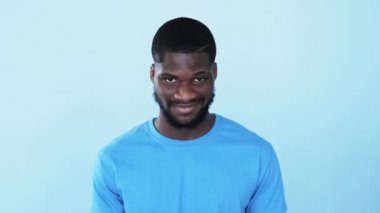 Mutlu afro adam. Siyahların hayatı önemlidir. Irksal hoşgörü. Kendine güvenen, güler yüzlü, dost canlısı gülümseyen, mavi, boş bir arka planda izole edilmiş Afrikalı adam..