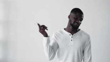 Sıkıcı bir telefon görüşmesi. Sinirli Afrikalı adam. Bumerang animasyonu. Cep telefonu dolandırıcılığı. Cep telefonu gif döngüsünü görmezden gelen rahatsız siyah adam beyaz kopya alanı arka planında izole edildi.