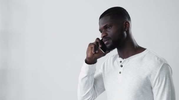 모바일 자신감 미소를 아프리카 남자가 핸드폰으로 얘기하는 배경에 고립되어 — 비디오